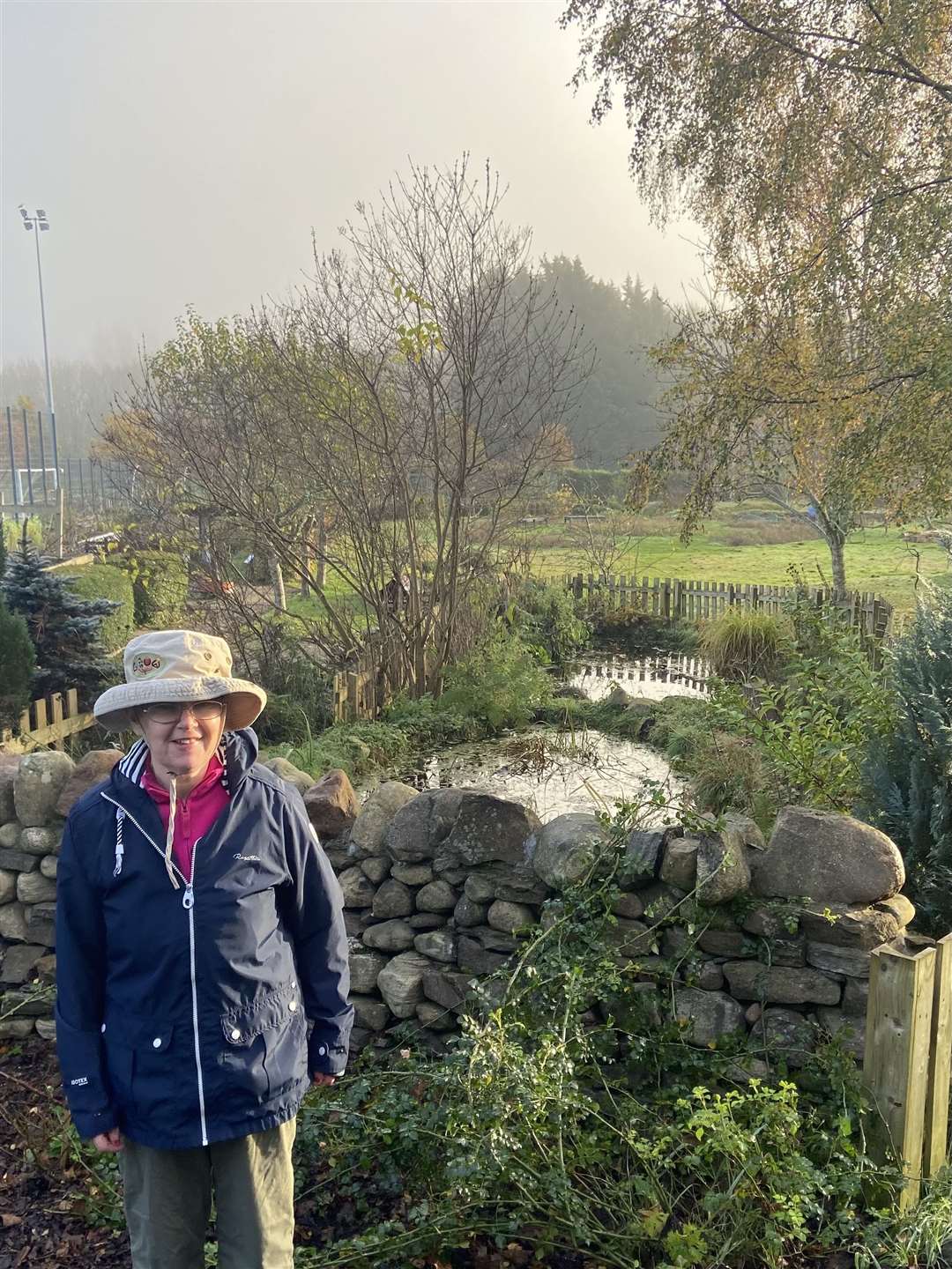 Carol with her ponds and beautiful stone wall.